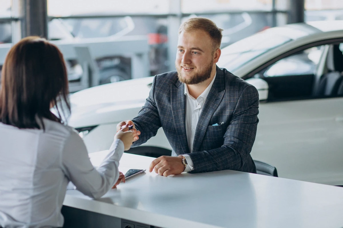 man with sales woman in car showroom