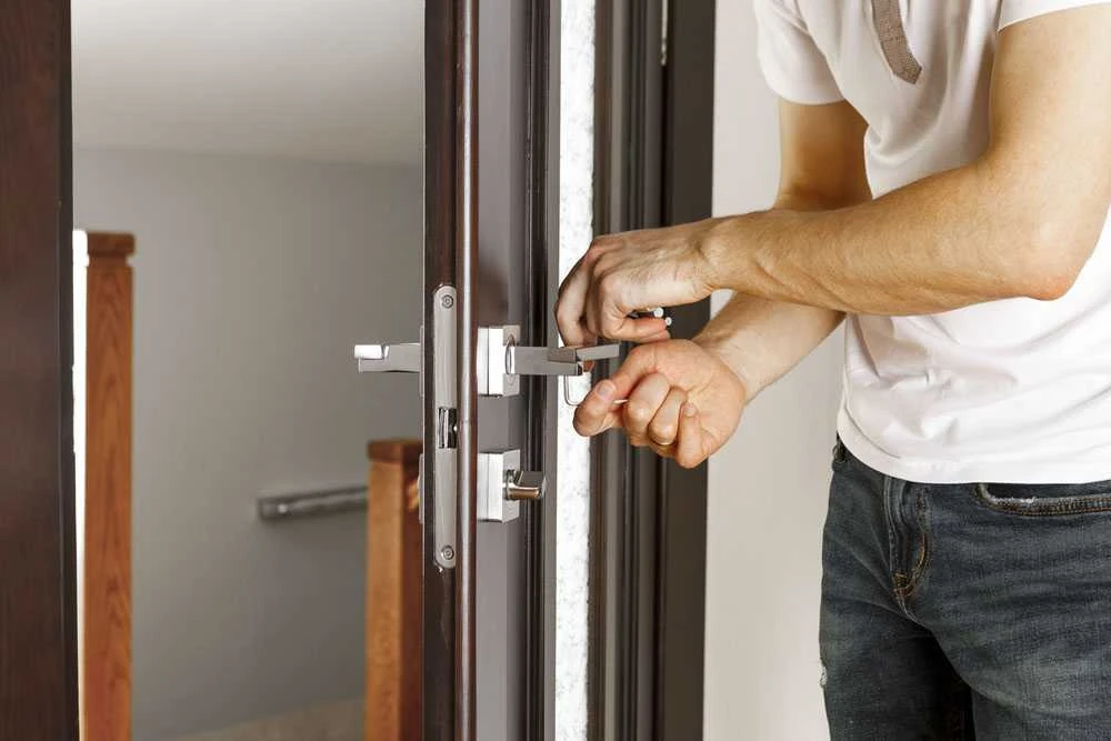 man repairing doorknob2 Avarinis atrakinimas, su kuo dažniausiai susiduria žmonės?
