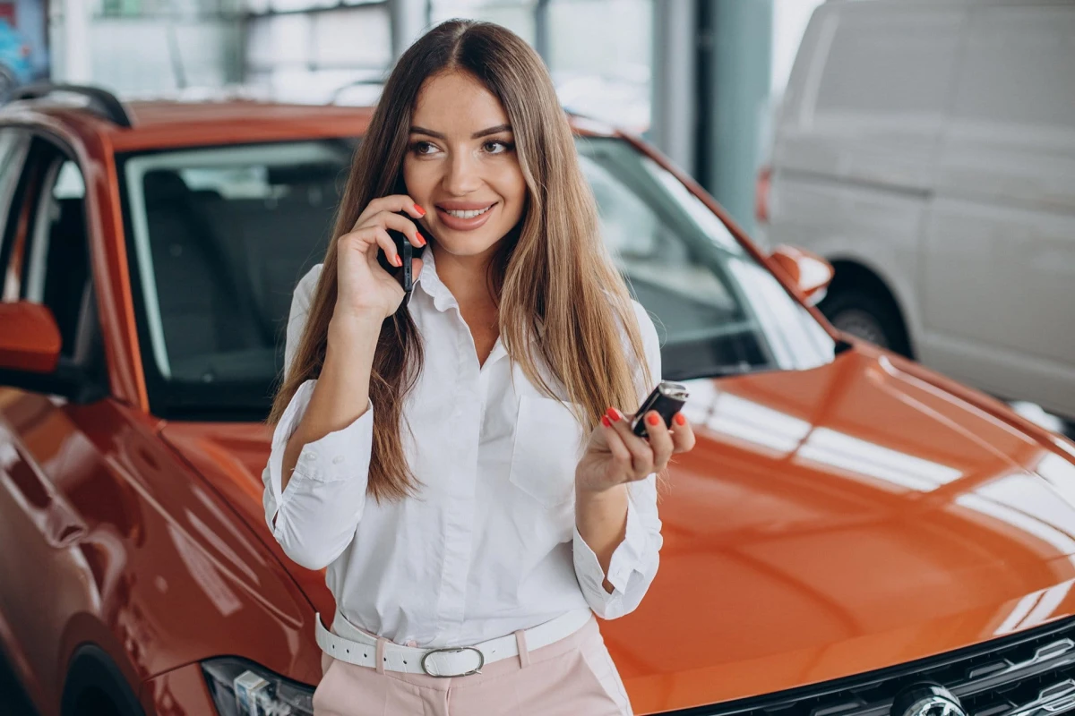 woman holding car keys by her new car